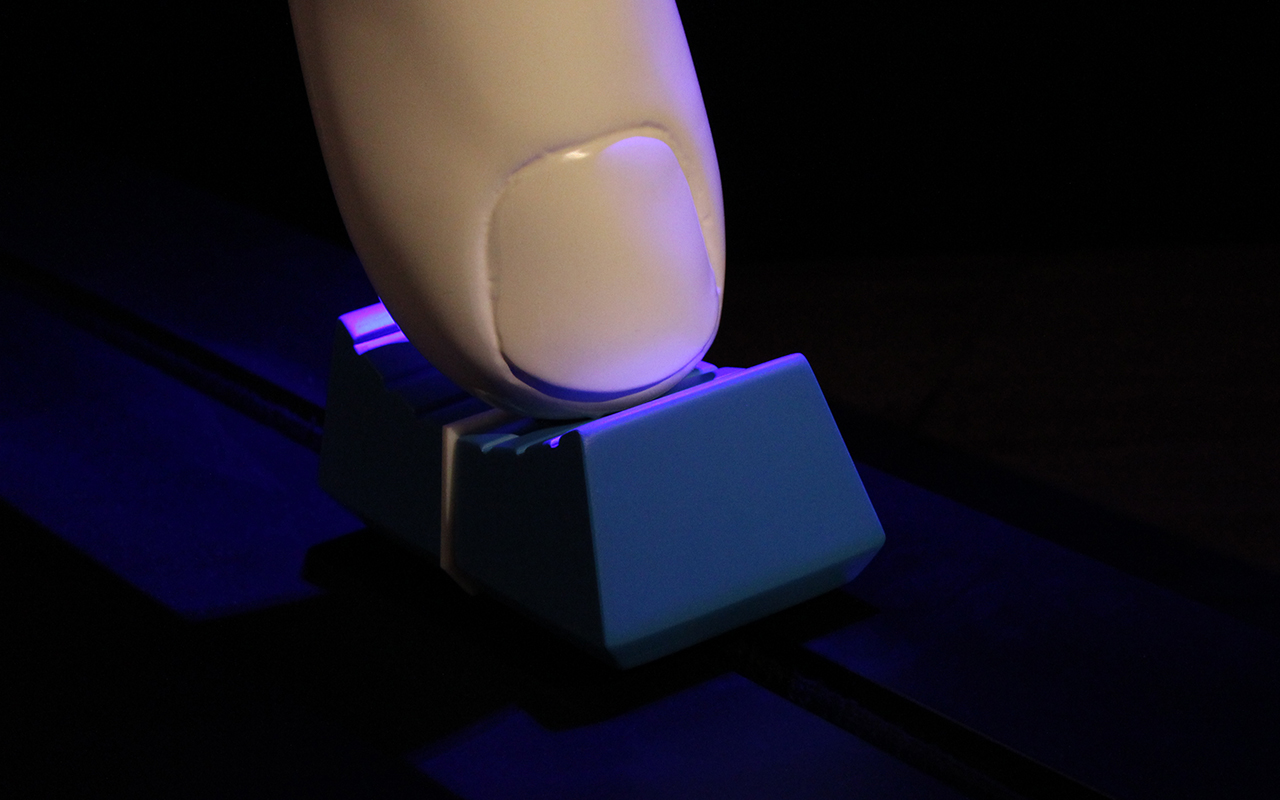 A detail shot of the large finger sitting on top of the blue cap.